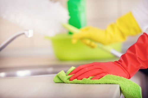 Technician applying carpet cleaning treatment with safety precautions